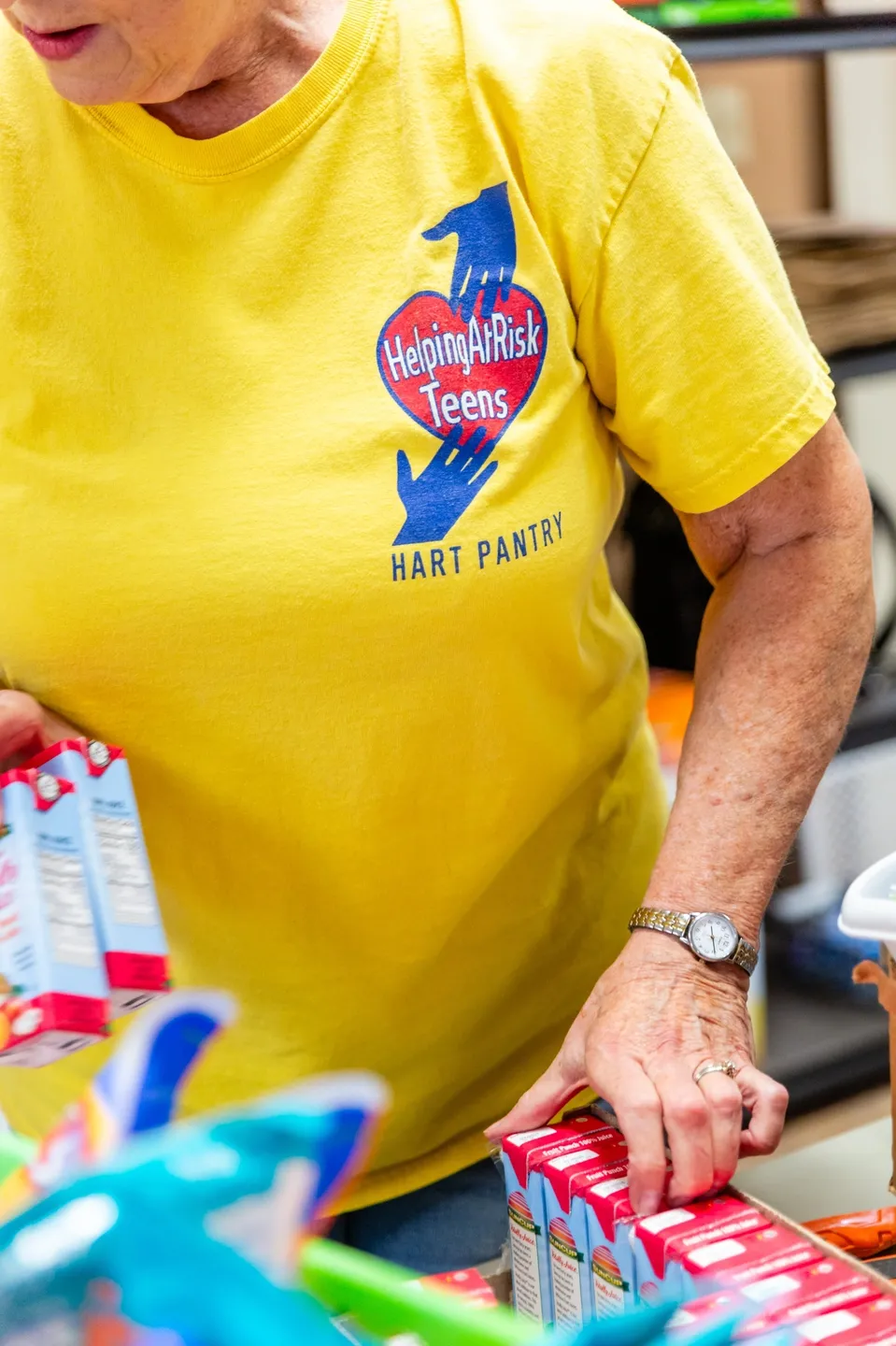 A woman in yellow shirt holding onto some bags