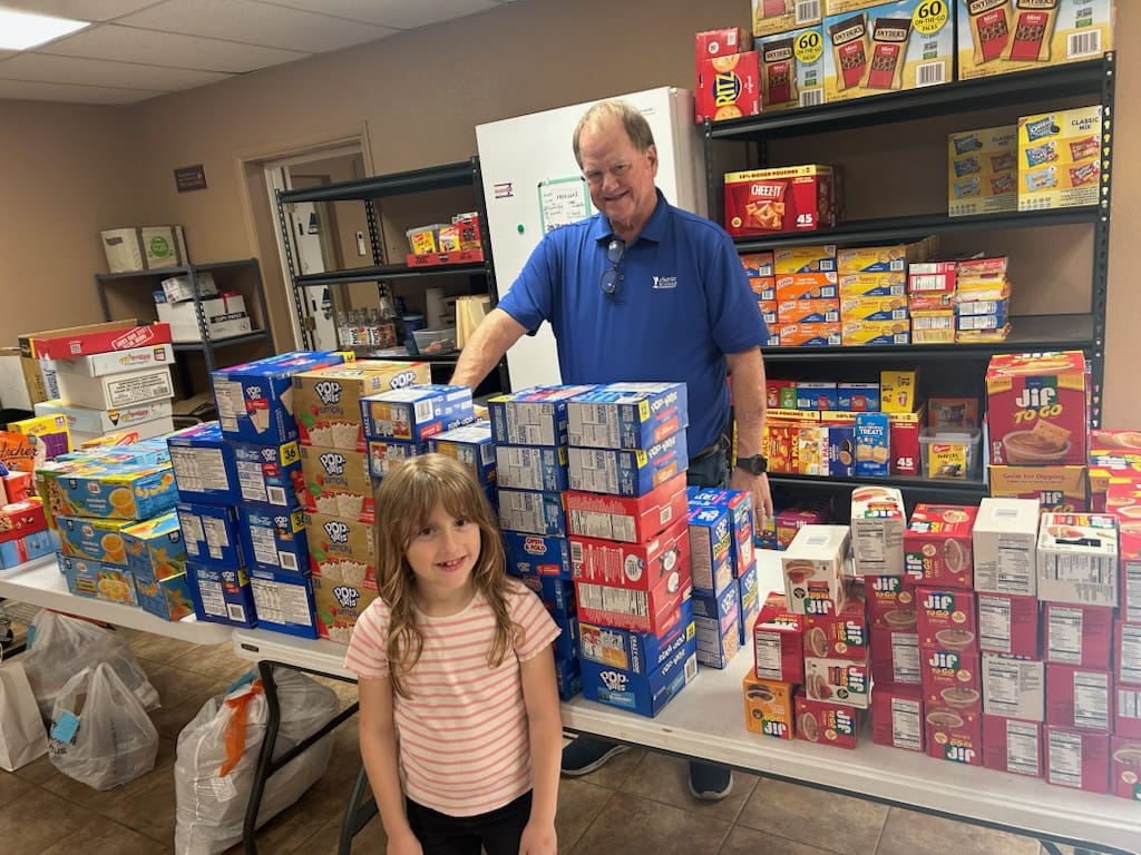 Girl and volunteer sorting food pantry donations