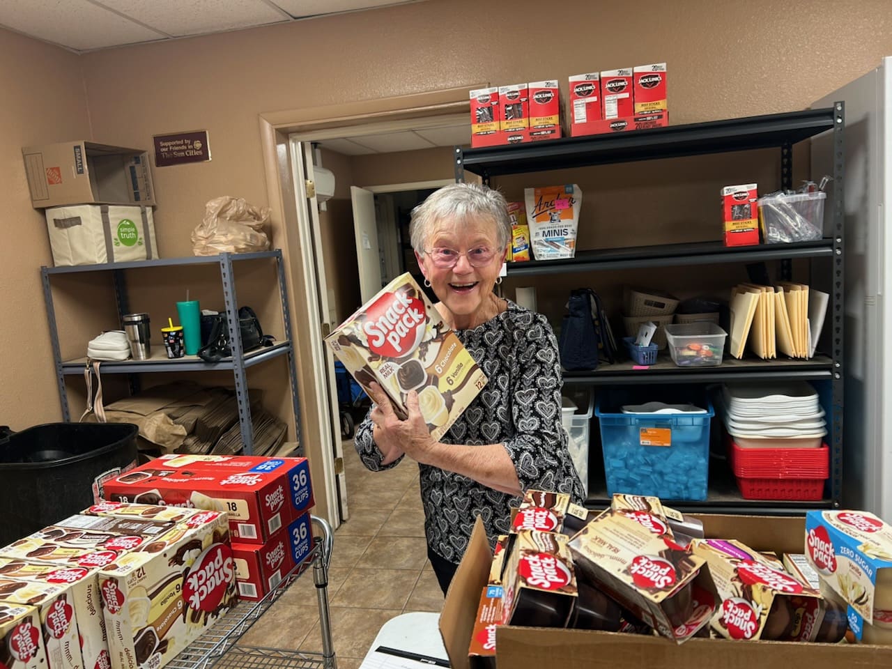Smiling senior holding Snack Pack pudding boxes
